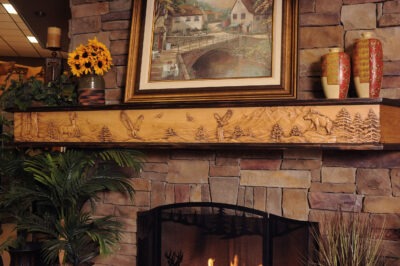 Wildlife Chorus fireplace mantel with 8 point buck, bear and eagle mountain scene.