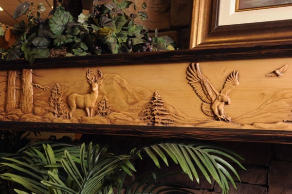Wildlife Chorus fireplace mantel with 8 point buck and eagle mountain scene.
